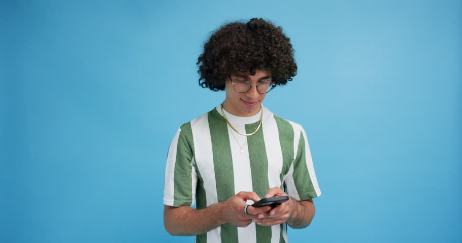Studio, man and smile with smartphone for chat, online communication and comment for digital reel. Mockup space, male person and laughing with mobile app for social media, meme and blue background