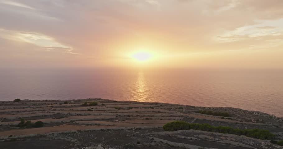 Sunset over the sea on the island of Malta aerial view. Orange-red sky over the Mediterranean Sea, beautiful untouched nature. High quality 4k footage