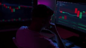Tired young trader man experiencing headache while analyzing graphs on computer in dark home office room at night. Investor studying cryptocurrency or forex market charts. Concept of financial crisis. - Powered by Shutterstock - Get 15% off with code: PIKWIZARD15