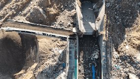 Drone view of a waste recycling facility with tractors processing construction debris on a rubble mountain. The industrial site highlights eco-friendly recycling operations, heavy machinery - Powered by Shutterstock - Get 15% off with code: PIKWIZARD15