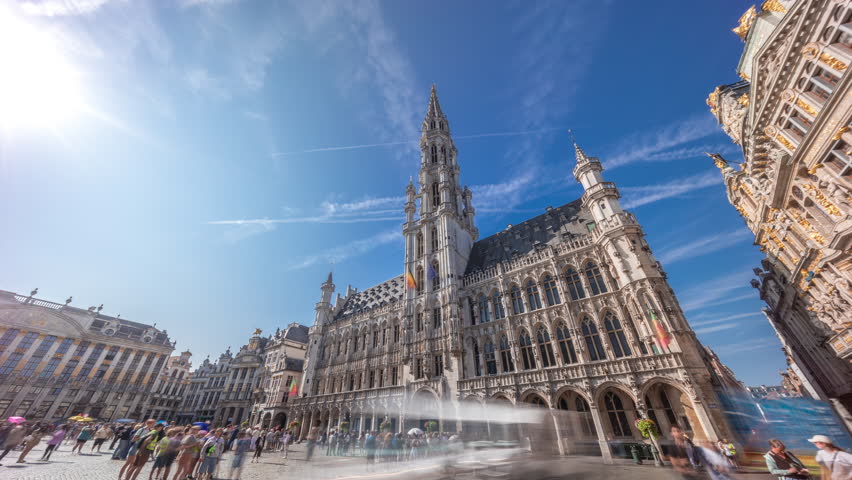 Timelapse hyperlapse of Town Hall (Hotel de Ville) on the Grand Place in Brussels, Belgium. Looking up at the Gothic tower and facade. A UNESCO World Heritage Site and major tourist destination