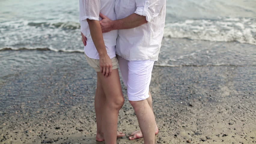 Happy couple in love standing by the sea
