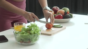 A young Asian housewife enjoys a healthy lifestyle at home, balancing fitness routines with relaxation. She sits on a modern sofa, eating a fresh salad and fruit while embracing healthy habits. - Powered by Shutterstock - Get 15% off with code: PIKWIZARD15