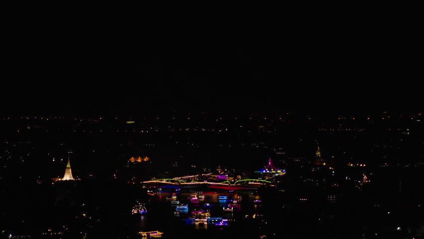 Powerful large-scale grandiose flash lights fireworks sparks explosions in the sky among buildings skyscrapers night city, Firework display and light show at Bangkok’s River to promote tourism