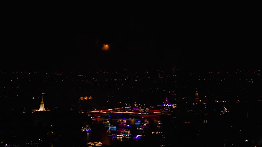 Powerful large scale grandiose flash lights fireworks sparks explosions in the sky among buildings skyscrapers night city, Firework display and light show at Bangkok’s River to promote tourism