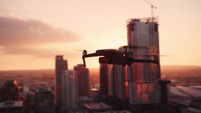 Drone Flight Over City Skyline at Sunset – Aerial View of Buildings and Technology in Real-Time with Handheld Camera