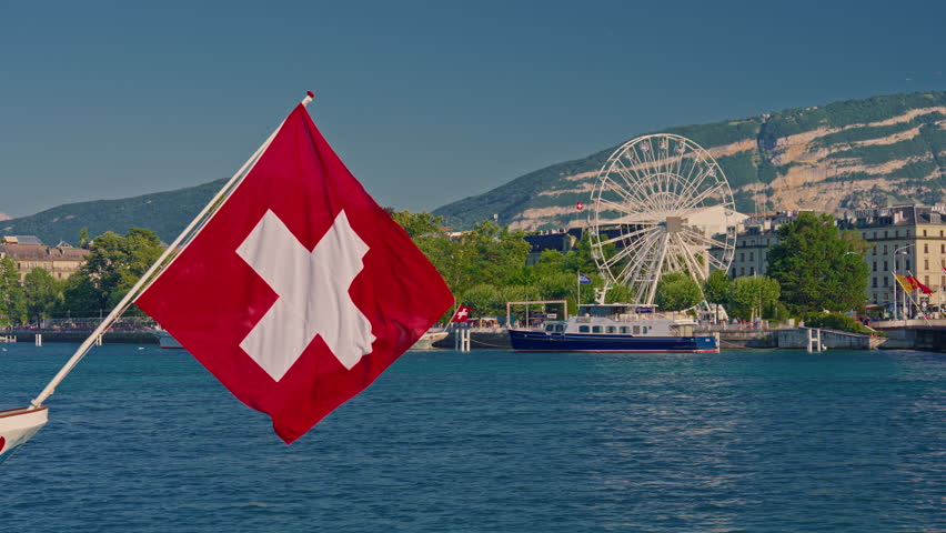 Swiss flag against a blue clear sky in a summer day in Switzerland