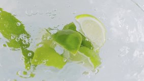Fresh lime slices splashing into water in slow motion 300fps - Powered by Shutterstock - Get 15% off with code: PIKWIZARD15