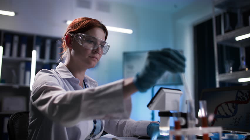 modern medicine, female medecins sans frontieres conducts medical research with the help of microscope and reagents in the laboratory