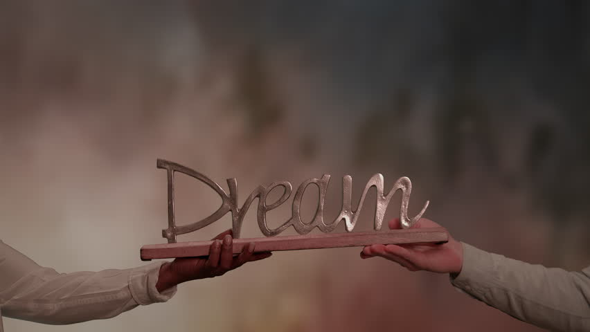 Two people holding a dream logo sign together - sharing happiness