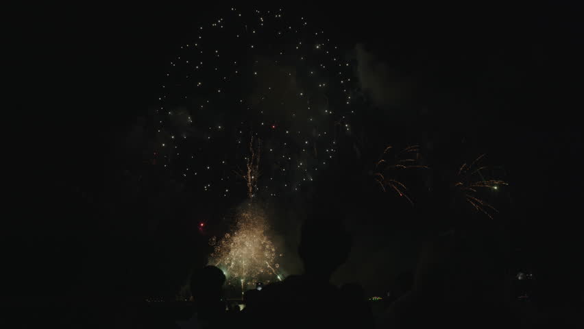 A festive night in Pattaya, where fireworks light up the dark sky with bursts of red, blue, and yellow, symbolizing joy and celebration.