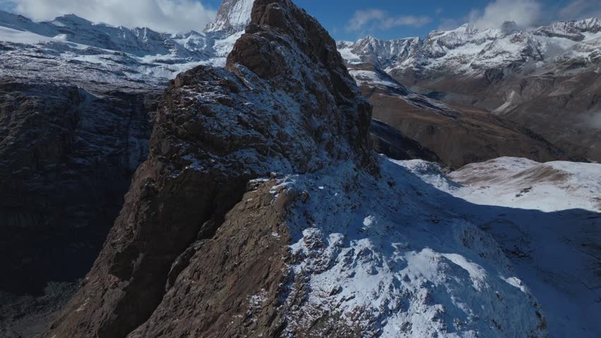 Matterhorn famous mountain peak rocky cliffs Riffelsee Lake Zermatt Swiss Alps aerial drone first fresh snow fall autumn winter blue skies morning Gornergrat railway Switzerland forward pan up