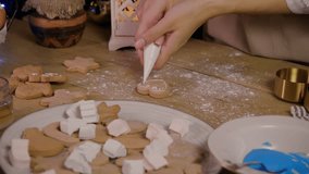 Pastry chef girl creates a classic Christmas gingerbread cookie. She uses icing to decorate it - Powered by Shutterstock - Get 15% off with code: PIKWIZARD15