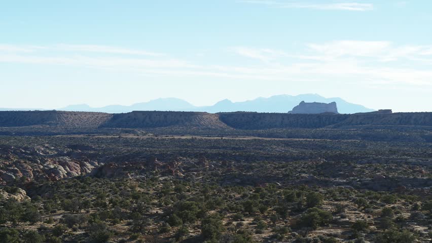 Aerial of San Rafael Swell in central Utah at sunset with canyons and mesas in horizon