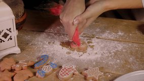 Pastry chef decorates Christmas gingerbread cookies with red icing in the shape of heart. Process of creating festive treats for Christmas Eve by housewife. - Powered by Shutterstock - Get 15% off with code: PIKWIZARD15
