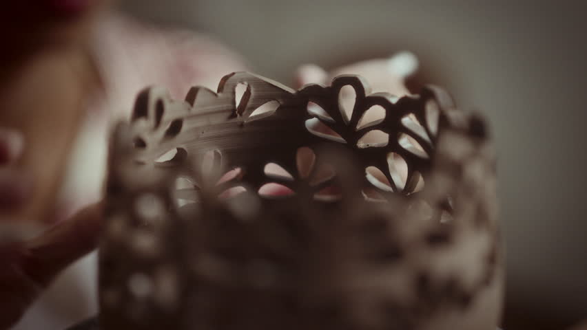 Close-up of intricate, hand-carved patterns on unique pottery, showcasing the artisan's craftsmanship and attention to detail