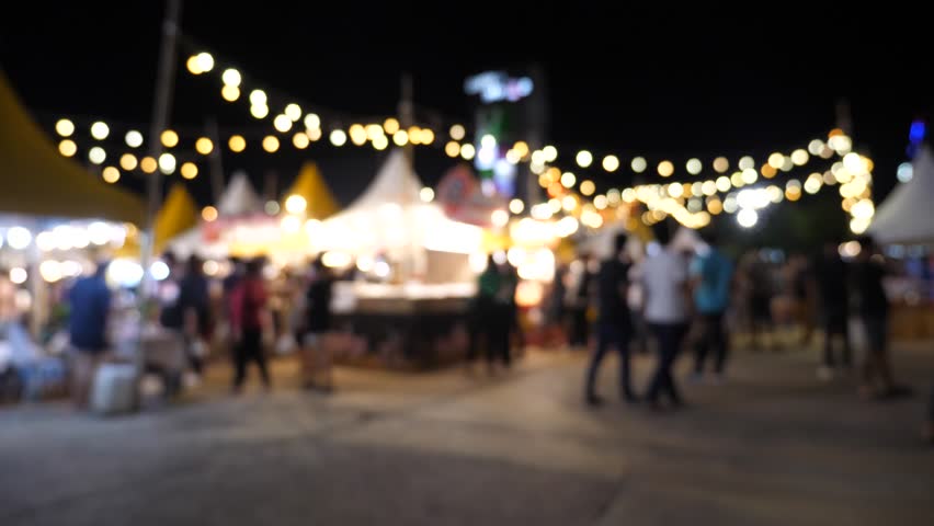 Slow motion of blurred busy busy fresh market full with crowd people walking in street shopping.
Thailand street food night market booth festival light bright bokeh.