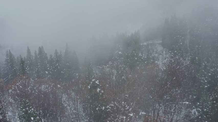 Drone footage: Snowy mountains covered in deep fog