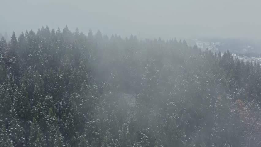 Drone footage: Snowy mountains covered in deep fog