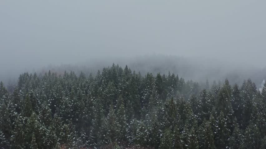 Drone footage: Snowy mountains covered in deep fog
