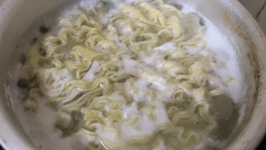 A pot of noodles is cooked in boiling water