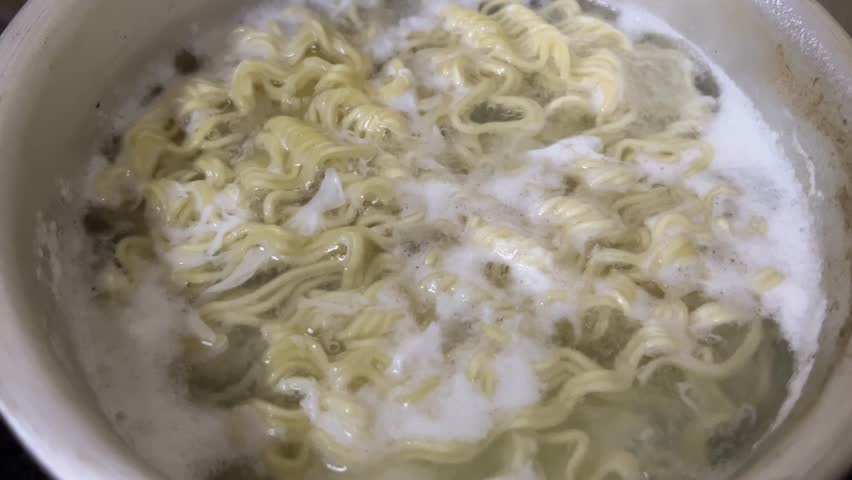 A pot of noodles is cooked in boiling water