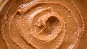 Peanut butter background rotating. Creamy smooth peanut butter swirl backdrop. Organic food. American cuisine. Vegan food. Slow motion. Top view, view from above.  - Powered by Shutterstock - Get 15% off with code: PIKWIZARD15