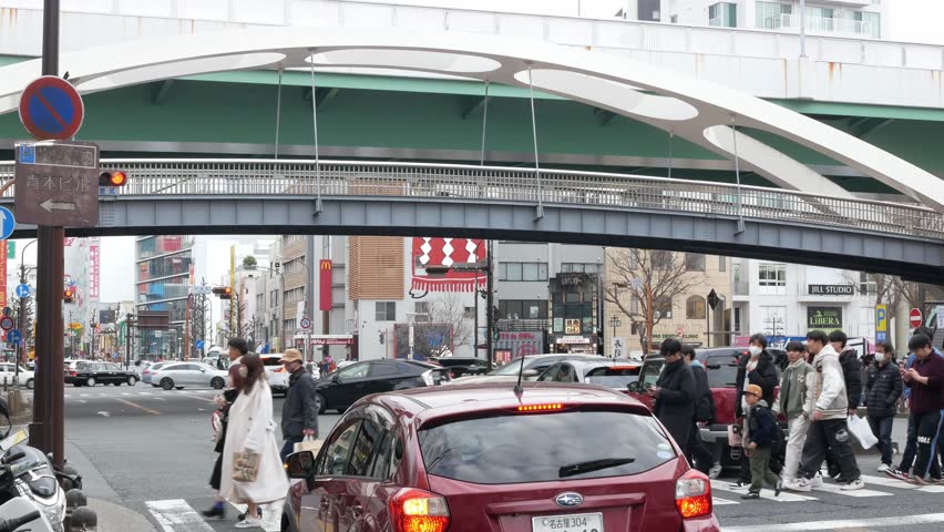 Febuary3,2024.Nagoya,Japan.aerial street view at nagoya central business district area at intersection while pedestrian crossing the road in sunny time, crossing street in nagoya area