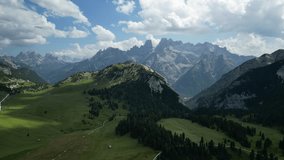 A drone view of green land with trails and trees in a mountainous landscape with clear sky in braies, Italy - Powered by Shutterstock - Get 15% off with code: PIKWIZARD15