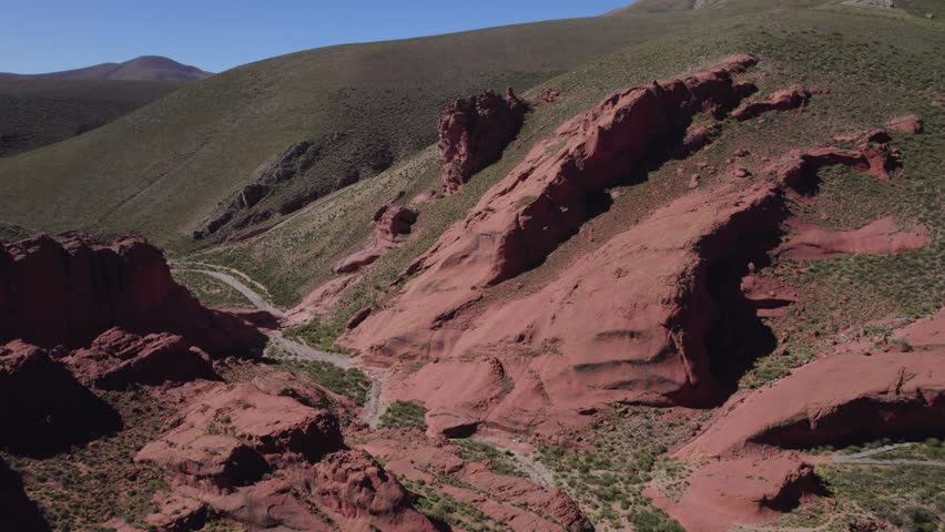 A drone footage of dramatic rock formations, hills and rocky, multihued slopes in the mountain valley Quebrada de Humahuaca in Jujuy, Argentina