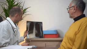 Confident male doctor explaining chest X-ray on image to senior male patient, discussing diagnosis and recommending treatment options during medical consultation in clinic. - Powered by Shutterstock - Get 15% off with code: PIKWIZARD15