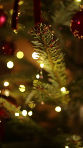 Happy New Year Christmas tree decorates with red glass ball on branch on background bokeh of side flickering light bulbs garlands for family winter holiday. Festival mood. Noel. 