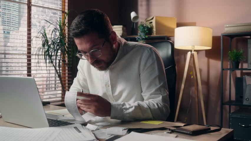 Stressed Caucasian salesman accountant man ceo boss manager guy holding bill male employer reading paper in office business finance sad businessman counting costs money loss problem bankruptcy taxes