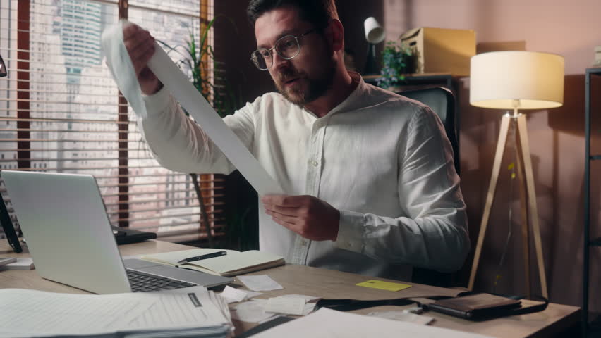 Stressed Caucasian salesman accountant man ceo boss manager guy holding bill male employer reading paper in office business finance sad businessman counting costs money loss problem bankruptcy taxes