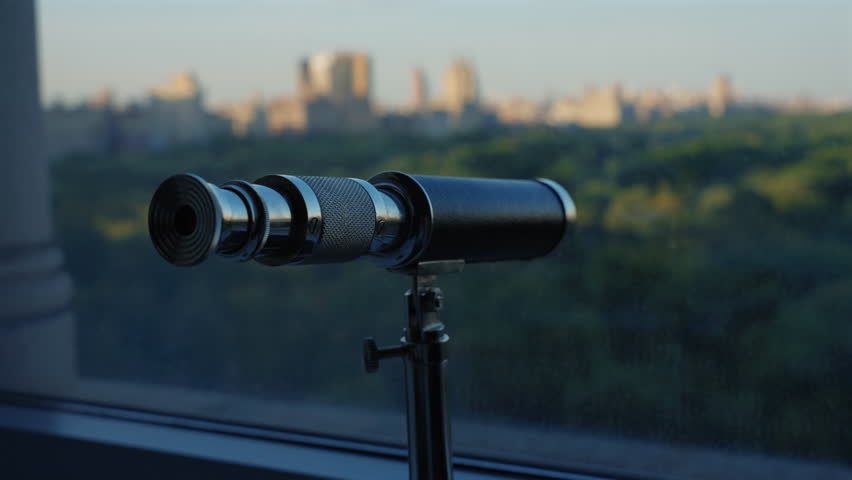 Vintage telescope overlooking a New York city skyline at dusk Central Park. telescope with which you can see all of New York. A telescopic view of a distant skyline with a telescope at the city