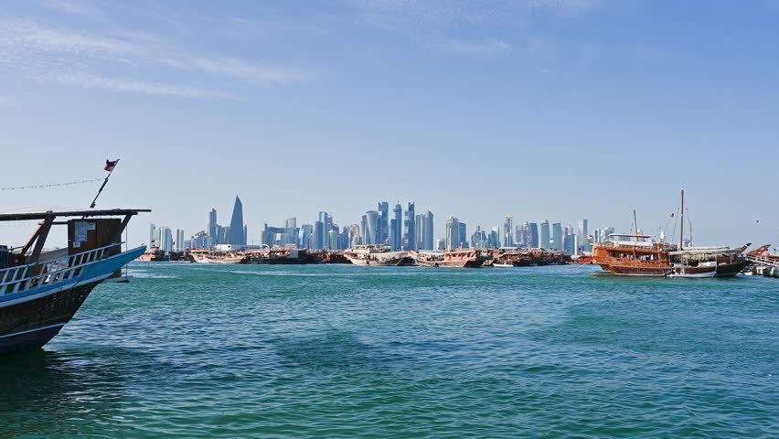 View of city centre buildings and tour boats passing by the seafront from the souq waqif area in Doha, Qatar