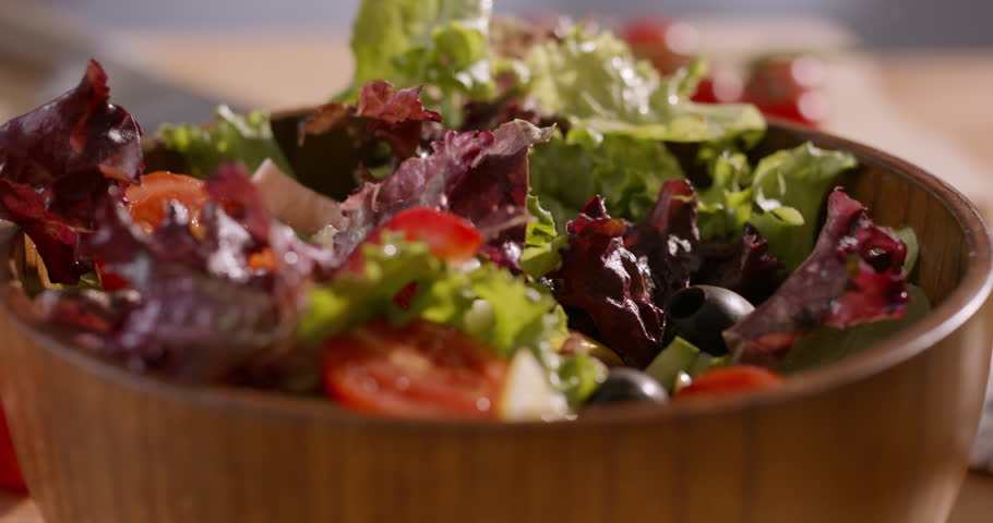 Appetizing Close-Up of Fresh Ingredients Falling into a Mediterranean Salad, Emphasizing Healthy Lifestyle and Wholesome Home Cooking
