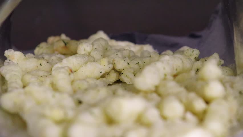 Taking  potato stick corn  chips from a packet by hand close up 4k footage. Lots of junk food, macro video.
