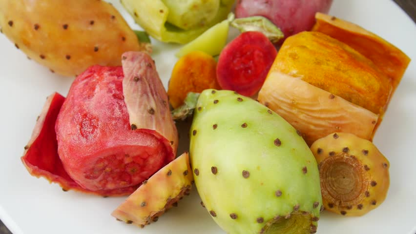 Cut prickly pear cactus fruits on a plate.