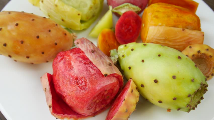 Cut prickly pear cactus fruits on a plate.
