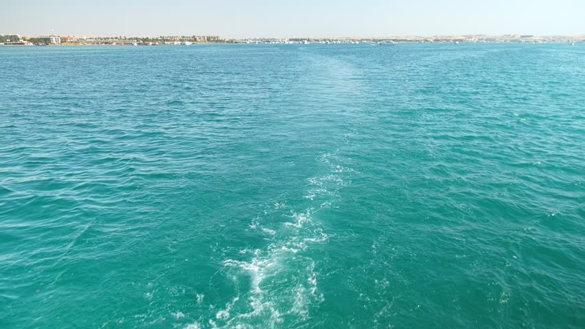 Cruising boat makes wake stream. Sailing in Red sea. White wake trails behind boat sailing in the sea. Seething water in the sea behind the ship
