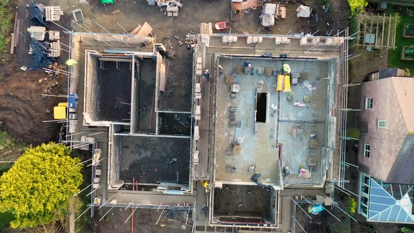 Aerial footage from the small town of Little Ribston in the Harrogate district of North Yorkshire, England showing a construction building site building two new houses on a farmers field