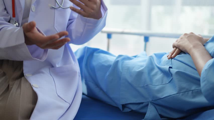 Doctor delivers bad news while providing comfort to a sad patient in a hospital room, fostering empathy and support