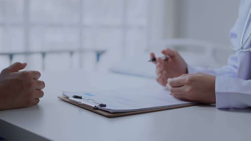 Doctor explaining treatment options to a patient in a medical office setting, fostering understanding and trust