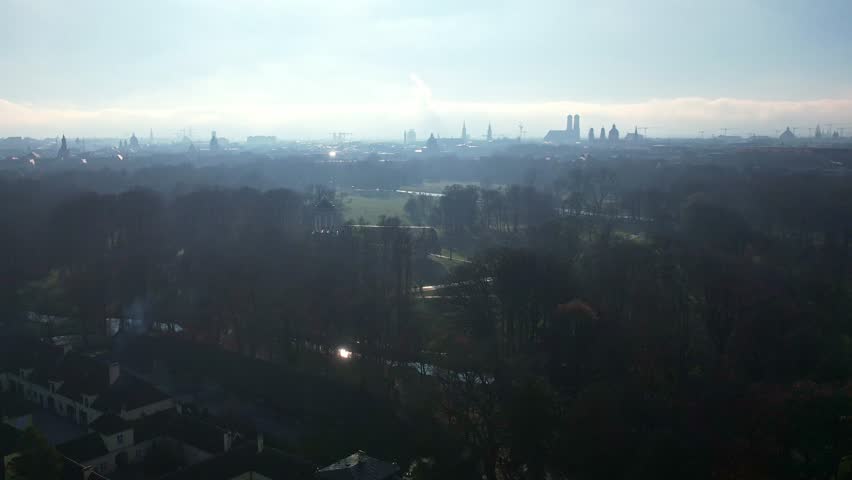 4K aerial drone video of Monopteros and Chinese tower, historical landmarks of Munich Germany centrally located English Garden public park overlooking the city panorama on a sunny and foggy autumn day