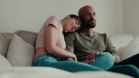 Happy couple relax on sofa, cuddling and pointing at TV. Love, home, relationship, together, interracial. - Powered by Shutterstock - Get 15% off with code: PIKWIZARD15
