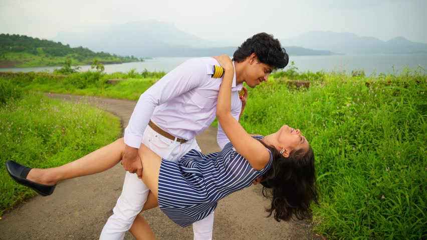 Naval Officer Embracing Wife in Outdoor Setup, Pilot Hugging Girlfriend and Gazing Affectionately, Spouses hold each other, Boy holds firmly, Female lean and looking up in the sky, Caressing, Indian