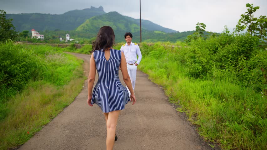 Girl approaching Boyfriend in Outdoor Setup, Naval Officer Cuddling Wife Affectionately in Arms, Spouses clasping one another, Smiling and embracing, In love, Boy squeeze girl at nature gently, Indian