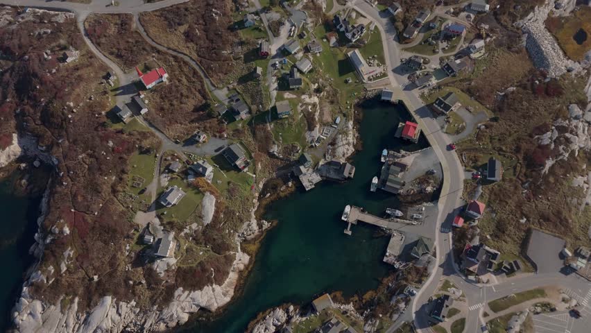 Top View The Charming Village Of Peggys Cove Features A Quiet Harbor With Boats. The Iconic Lighthouse Stands On The Rocky Shoreline, Highlighting The Beauty Of Southern Nova Scotia.