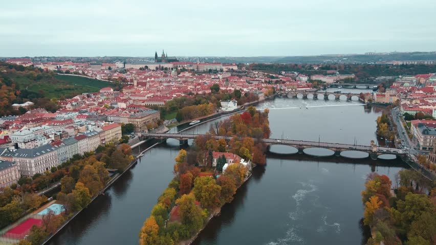 Aerial view of cityscape of Prague with colorful autumn trees on island on Vltava river. Architecture of Praha, Czech Republic